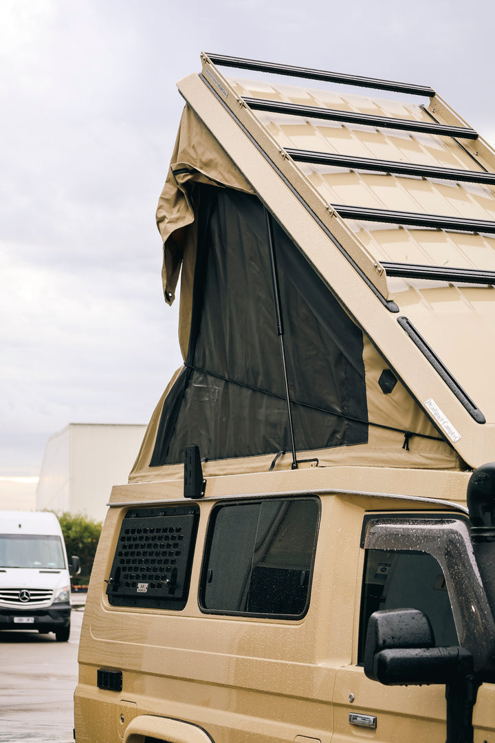 Close-up of a raised pop-top roof on a sand Troopy
