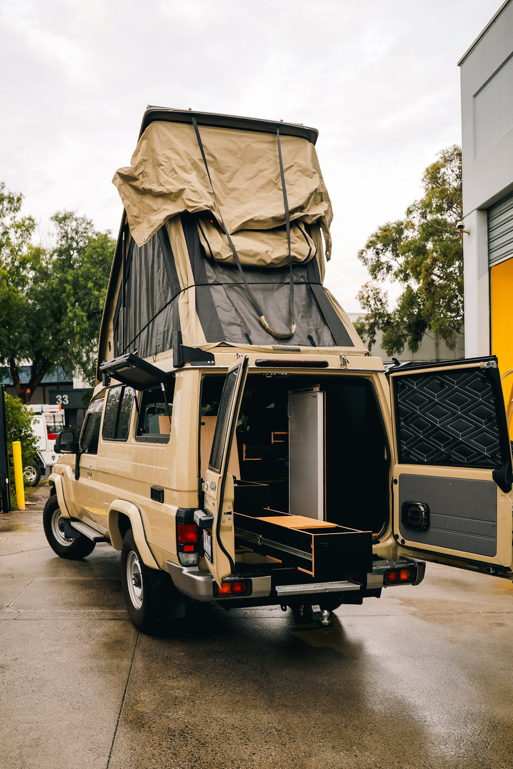 Sand Troopy from the rear with the pop-top up, barn doors open and a drawer pulled out