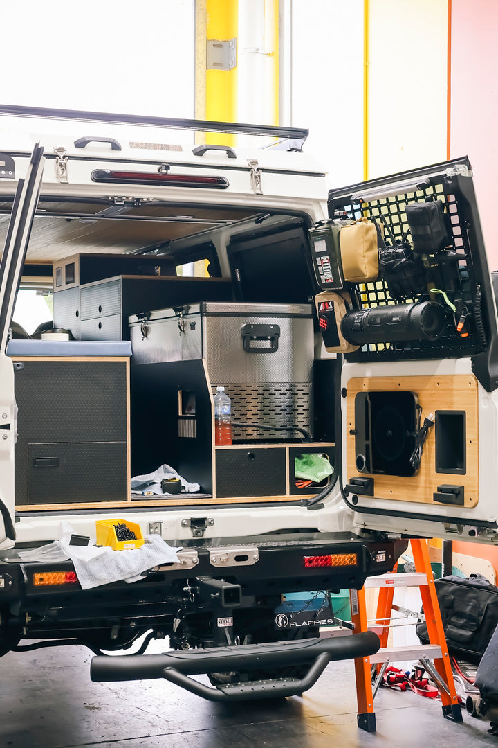A Troopy mid-build inside the Unwind workshop, rear doors open