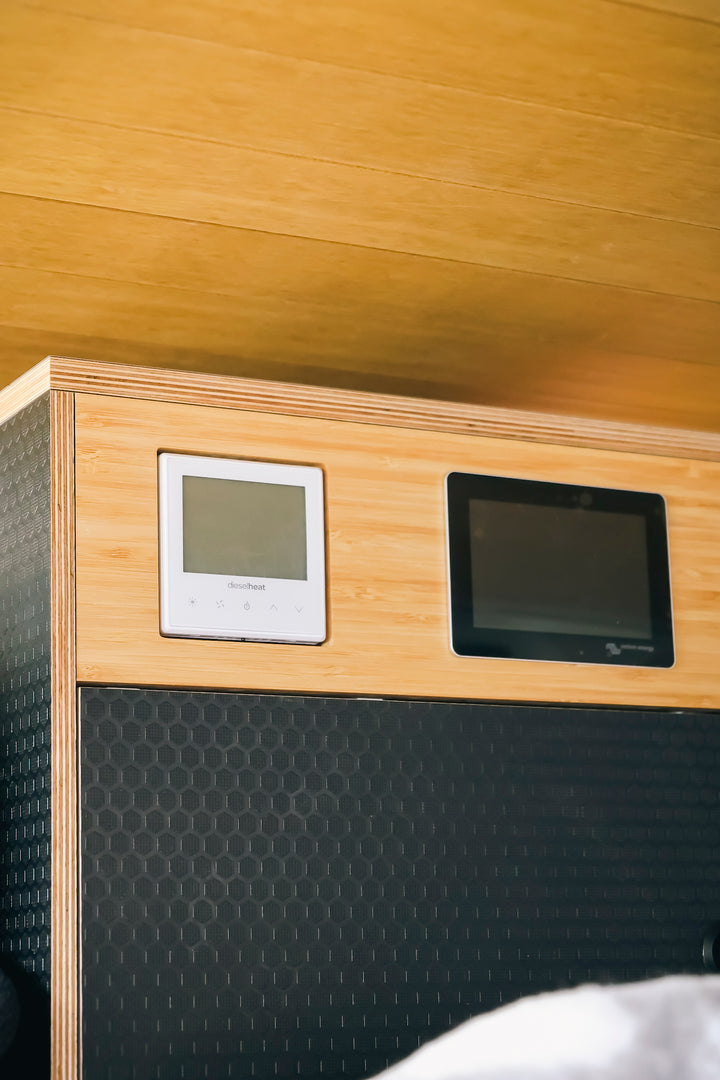 Two control screens set into a black cabinet with bamboo lining